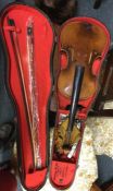 An old wooden cased violin together with two bows.