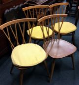 ERCOL: A set of four beech stick back chairs. Est.