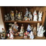A shelf of decorative porcelain clowns. £15 - £20.