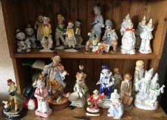 A shelf of decorative porcelain clowns. £15 - £20.