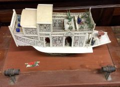 An unusual carved ivory model of a boat in glazed