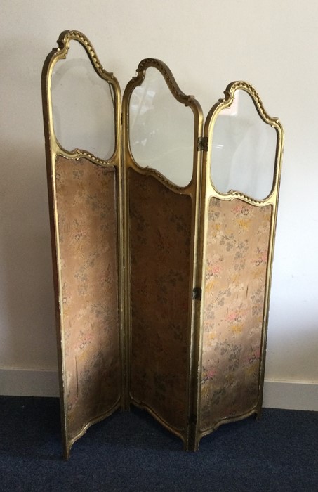An unusual gilt three-fold screen with upholstered