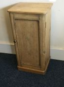 A pine single door bedside cabinet with panelled f
