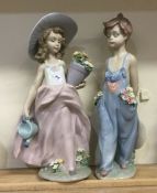 Two large Lladro figurines of children on green fl