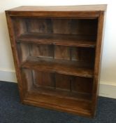 A stripped pine open bookcase with plank back. Est