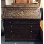 A Georgian style carved oak bureau decorated with