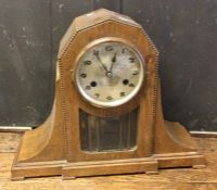 A tall oak mantle clock of shaped form. Est. £30 -