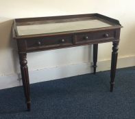 A Victorian two drawer writing table on turned sup