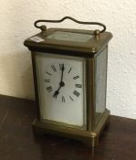 A brass carriage clock with white enamelled dial o