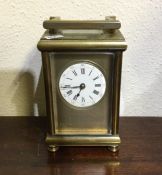 A heavy brass carriage clock on turned bun feet wi