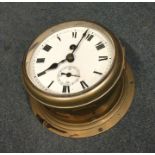 A large brass ship's clock with white enamelled di