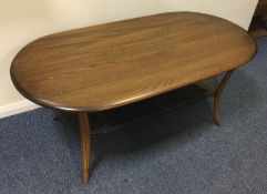 A large glass mounted Ercol coffee table on four s
