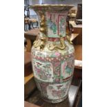 A tall Chinese vase decorated in bright colours. A