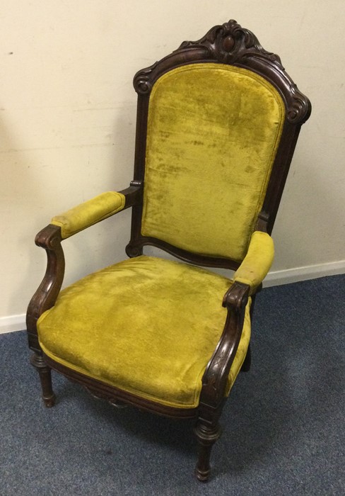 An Edwardian upholstered armchair with carved deco