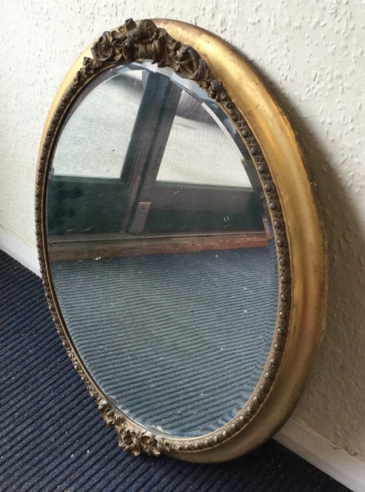 An oval gilt framed wall mirror. Est. £30 - £50.