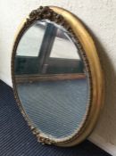 An oval gilt framed wall mirror. Est. £30 - £50.