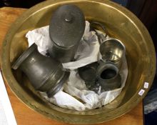 A selection of pewterware contained within a brass