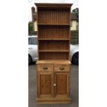 A stripped pine bookcase with two drawers. Est. £20