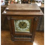 An Edwardian oak mantle clock with brass dial to t
