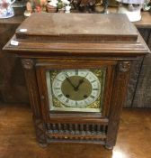 An Edwardian oak mantle clock with brass dial to t