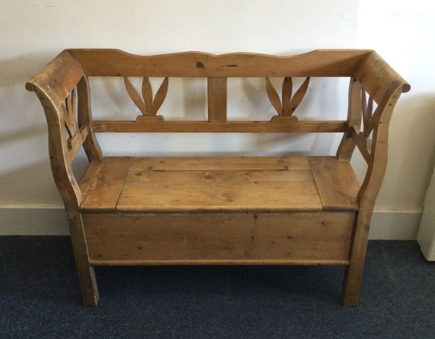 A stripped pine settle with shaped edge. Est. £60