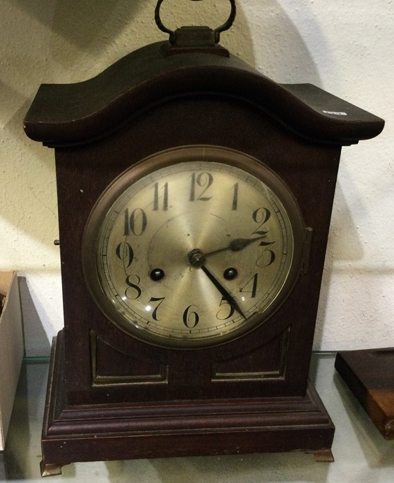 An oak cased shaped top clock with silvered dial.