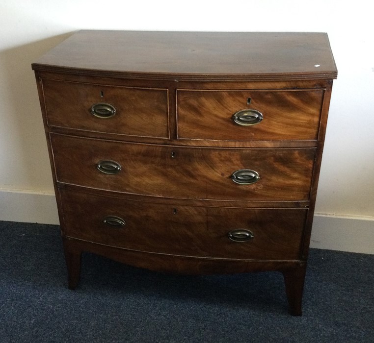 A Georgian mahogany bow front chest on four taperi