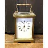 A brass mounted carriage clock on bracket feet wit