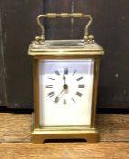 A brass mounted carriage clock on bracket feet wit