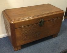 A large hinged top trunk with carved decoration. E