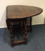 A large oak drop leaf table on turned supports. Es