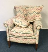 A Victorian upholstered armchair on tapering suppo