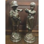 A good pair of bronzed figures of children with ou