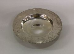 A large circular silver armada dish of typical for