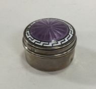 A circular silver and enamelled hinged top box. Bi