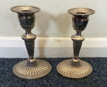 A pair of Edwardian silver candlesticks of half fl