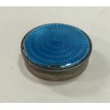 A circular silver and blue enamelled counter box.