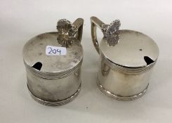 A pair of Edwardian silver mustard pots with shell