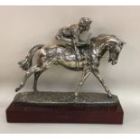 A good silver figure of a jockey on horseback on w