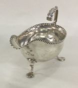 A George III silver sauce boat with crimped rim on