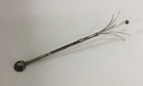 A silver swizzle stick of typical design. Approx.