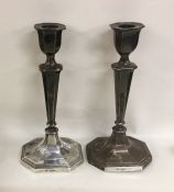 A tall pair of silver candlesticks on spreading ba