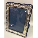 A large silver mounted picture frame with shaped d