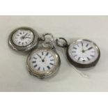 A group of three silver fob watches with white ena