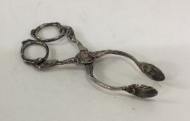 A pair of heavy cast silver sugar scissors with sc