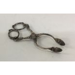 A pair of heavy cast silver sugar scissors with sc