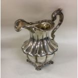 A good half fluted silver cream jug of shaped form