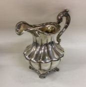 A good half fluted silver cream jug of shaped form