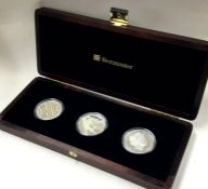 A boxed triple £5 coin set.