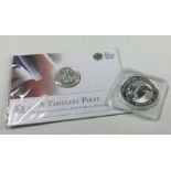 A silver 1 oz coin together with a 'Timeless First